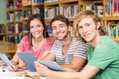 College students using digital tablets in library