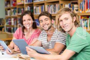 College students using digital tablets in library