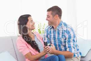 Man giving ring to woman at home