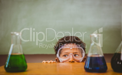 Boy looking at conical flasks in classroom