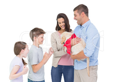 Parents gifting puppy to children against white background
