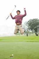 Excited golfer jumping up
