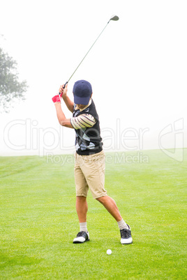 Golfer teeing off