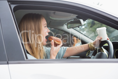 Young woman having coffee and doughnut