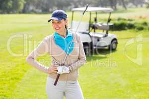Female golfer smiling with hands on hip