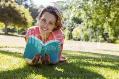 Pretty woman reading book in park