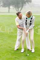 Golfing couple putting ball together