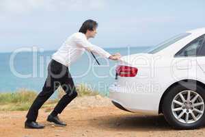 Businessman pushing his car