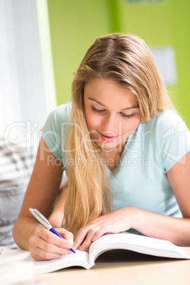 Female student doing homework in library