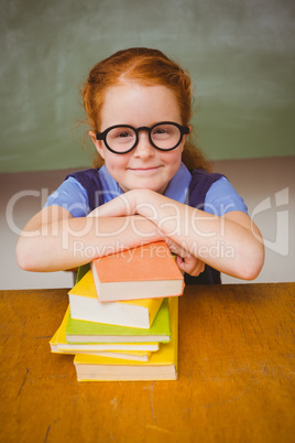 Cute girl with stack of books in classroom