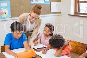 Cute pupils getting help from teacher in classroom