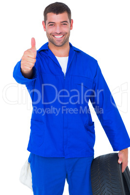 Mechanic with tire gesturing thumbs up