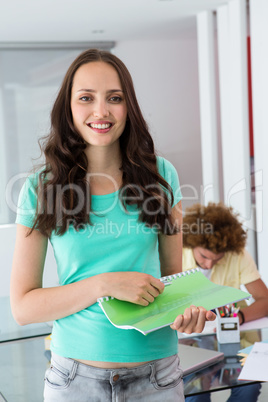 Portrait of smiling young woman with file
