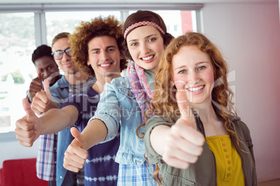 Students smiling in a single line with thumbs up