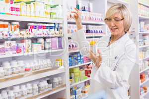 Smiling pharmacist looking at medicine