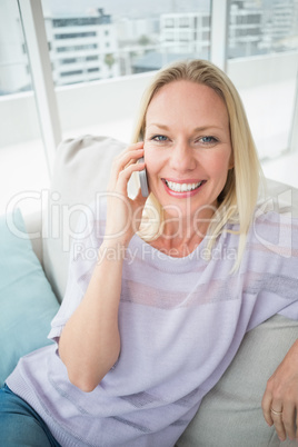 Woman talking on mobile phone in living room