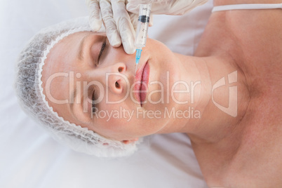 Woman receiving botox injection on her lips