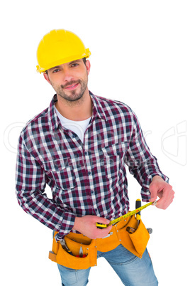 Smiling handyman holding tape measure