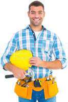 Smiling handyman holding hardhat and hammer