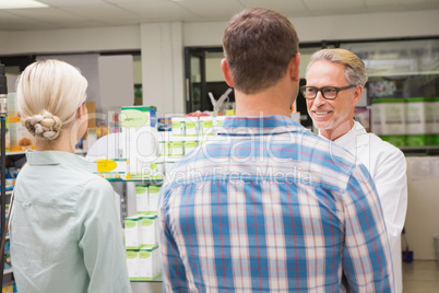 Pharmacist and customers talking about medication