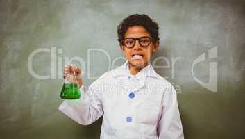 Cute boy holding conical flask in classroom