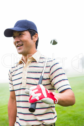 Smiling golfer standing and holding his club