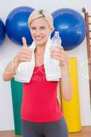 Blonde woman drinking water with thumbs up