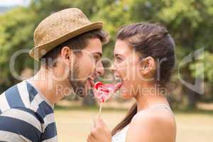 Cute couple sharing a lollipop