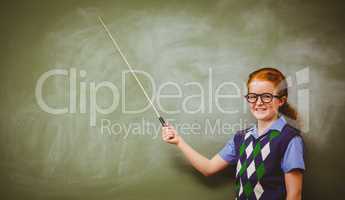 Little girl holding stick in front of blackboard