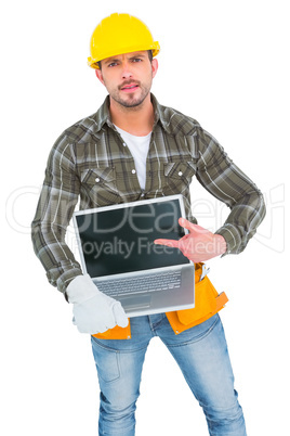 Angry handyman pointing at laptop