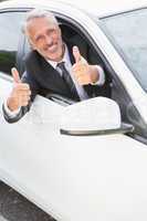 Businessman smiling at camera showing thumbs up