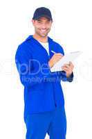 Portrait of happy male mechanic writing on clipboard