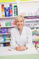 Smiling pharmacist posing behind the counter