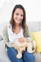 Beautiful woman with puppy on sofa