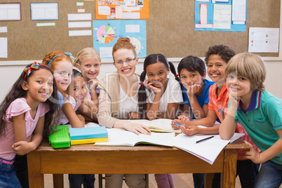 Teacher and pupils working at desk together