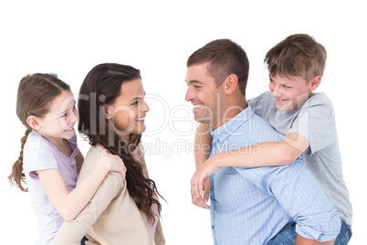 Happy parents giving piggyback ride to children