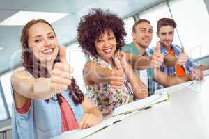 Fashion student smiling at camera with thumbs up