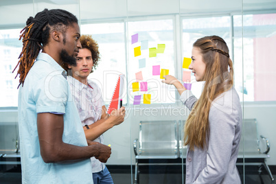 Creative team pointing at adhesive notes in office