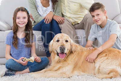 Siblings with dog and parents sitting behind