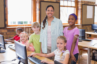 Cute pupils in computer class with teacher