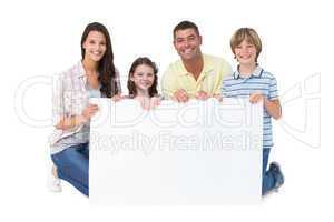 Happy family holding billboard over white background