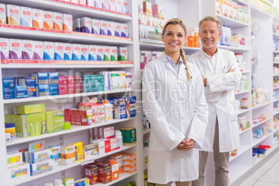 Pharmacist with his trainee standing and smiling at camera