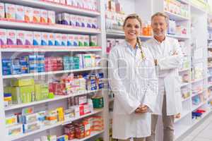 Pharmacist with his trainee standing and smiling at camera