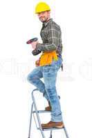 Repairman with drill machine climbing ladder