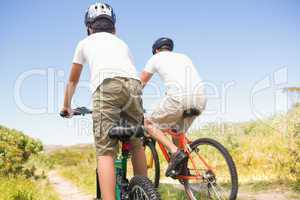 Father and son biking through mountains