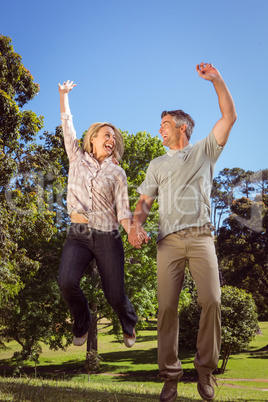 Happy couple jumping in the park