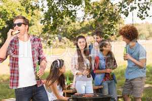 Happy friends in the park having barbecue