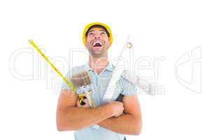 Laughing manual worker holding various tools