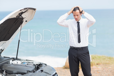 Stressed businessman looking at engine