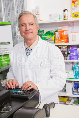 Smiling senior pharmacist using computer